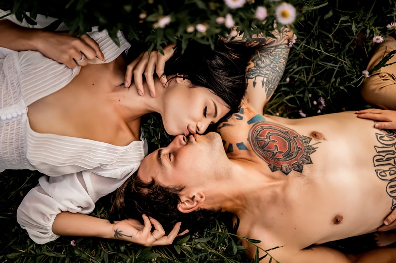 Salty Preset Pack, man and woman lay in a patch of flowers and kiss, she wears a deep-v blouse and he wears no shirt with tattoos covering body
