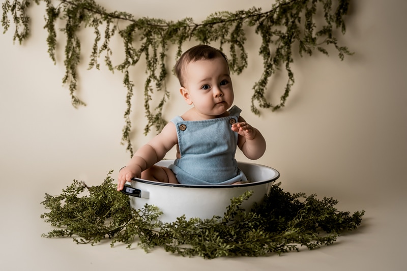 Moor Preset Pack, a young baby sits up in a cooking pot, he wears overalls and there are forest green plants around him