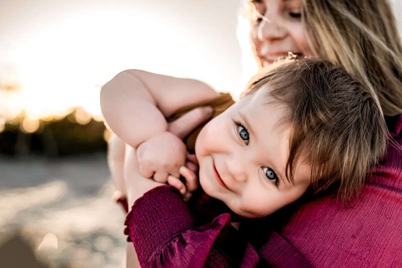 Salty Preset Pack, a young woman holds onto her baby playfully as baby smiles at the beach