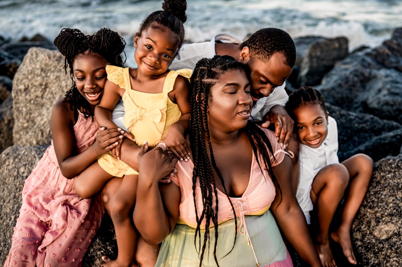Salty/Moor Preset Pack, lightened and edited images, a family of five sits together joyful on rocks near the ocean