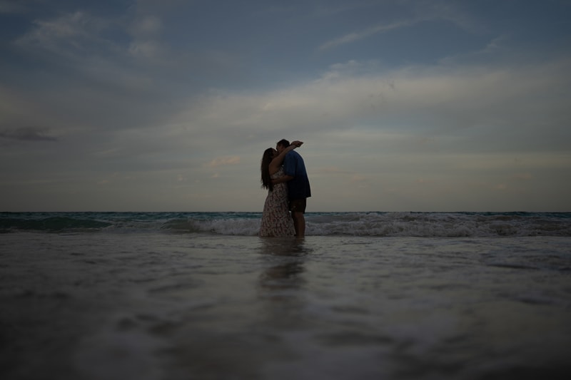 Dark Image - man and woman embrace in ocean waters 