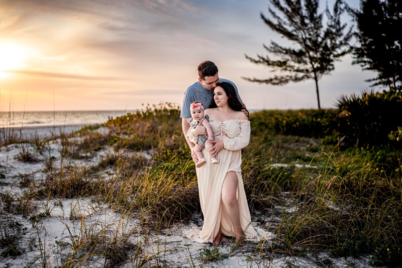 Salty Preset Pack, a husband kisses his wife on the forehead as she holds their baby girl at the beach