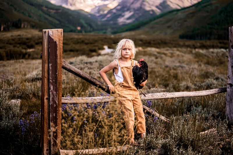 Salty Preset Pack a child leans on a wooden fence in the country holding a rooster, mountain-scape behind them
