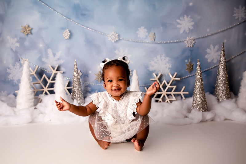 Moor Preset Pack, a baby girl sits up before a winter backdrop, snowflakes and glittery trees