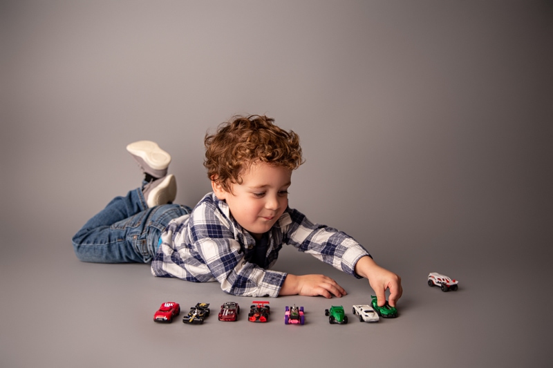 Moor Preset Pack, a young boy lays on the ground and lines up all his. toy cars as he plays