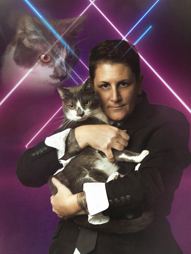 Michelle Peedee holds a cat in a tuxedo, laser lights behind her, the image of the same cat appears faded behind her and overhead as if watching over her