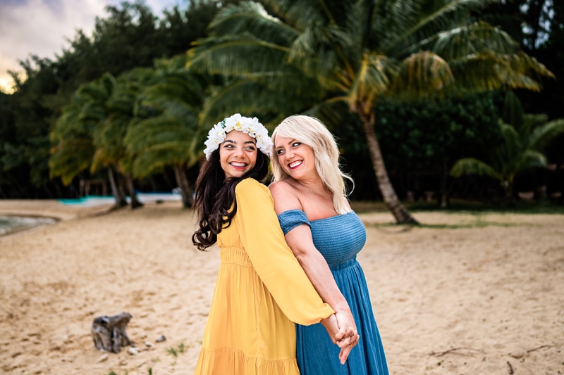 Salty Preset Pack, two girls stand back to back and smile over their shoulders, they hold hands on the beach in a tropical area